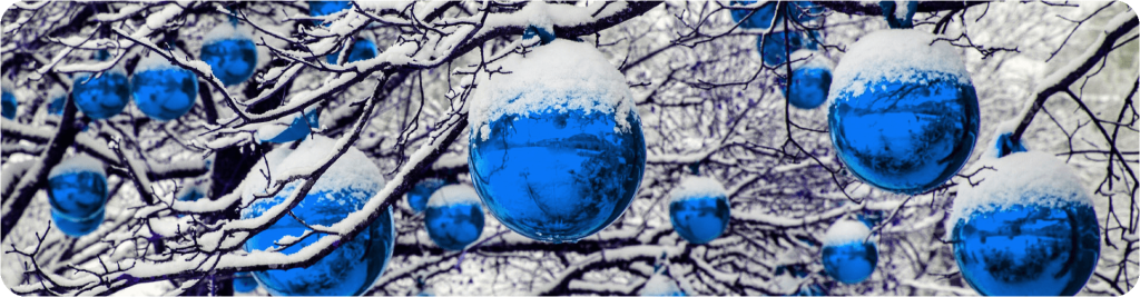 blue baubles covered with snow hanging from a tree